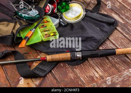 Verschiedene Angeltacles mit Rute und Rollen auf hölzernem braunem Hintergrund. Mockap für Werbung und Veröffentlichung. Stockfoto