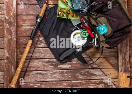 Verschiedene Angeltacles mit Rute und Rollen auf hölzernem braunem Hintergrund. Mockap für Werbung und Veröffentlichung. Stockfoto