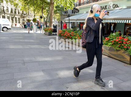 London, England, Großbritannien. Junge Frau mit langen Haaren, die sich auf ihrem Handy, Irving Street, filmte Stockfoto
