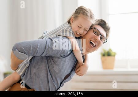 Glückliche liebevolle Familie. Papa und seine Tochter Kind Mädchen spielen zusammen. Vatertag Konzept. Stockfoto