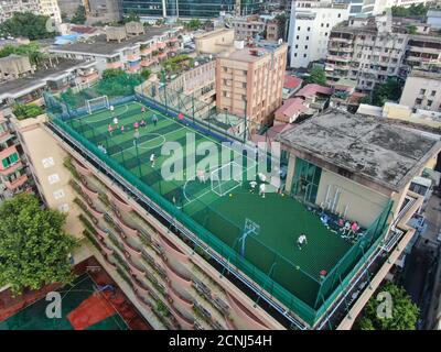 (200918) -- GUANGZHOU, 18. September 2020 (Xinhua) -- Luftaufnahme vom 17. September 2020 zeigt einen Blick auf den Sportplatz auf einem Lehrgebäude der Guangzhou Nr. 10 Mittelschule in Guangzhou, südchinesische Provinz Guangdong. Umgeben von dichten Wohngebäuden, beschloss die Guangzhou No. 10 Middle School, "vertikal zu entwickeln", um das Problem der unzureichenden Sportplatz zu lösen. Mit der finanziellen Unterstützung der Regierung und den Spenden ihrer Alumni baute die Schule schließlich auf ihrem Lehrgebäude einen Sportplatz mit allen notwendigen Einrichtungen wie schützendem n auf Stockfoto