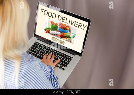 Nahaufnahme Frau sitzen und orde Essen online auf Laptop Computer in den Warenkorb Funktion Webseite bei Coffee Shop,Digital Marketingkonzept.digital Stockfoto