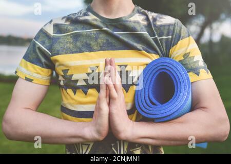 Yoga. Nahaufnahme Männer Hände. Junge Männer tun Yoga im Freien auf MAT.Guy Yoga auf dem Garten ausüben.Junge Männer meditieren in Lotus post Stockfoto