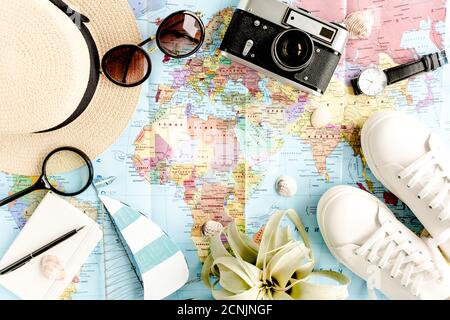 Reiseaccessoires auf Kartenhintergrund mit Retro-Kamera, Strohhut, Tasche, Sonnenbrille. Top View Reise- oder Urlaubskonzept. Flach liegend, Draufsicht. Stockfoto