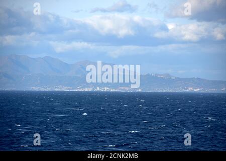 Gebirgige Mittelmeerküste von Marokko hinter der Straße von Gibraltar mit Stadtbild bei bewölktem, windigem Wetter mit moderatem, rauem Meer. Stockfoto