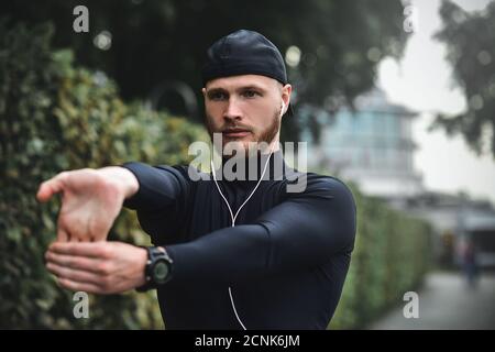 Muskulöse Sportler Stretching vor dem Sport Ausbildung an der Straße im City Park Stockfoto