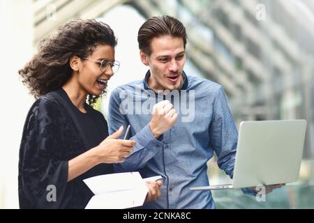 Geschäftstreffen. Mann und Frau diskutieren über die Arbeit und betrachten den Laptop-Bildschirm. Gemeinsam im Freien arbeiten. Stockfoto