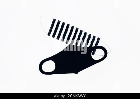 Schwarz-weiß handgemachte Gesichtsmasken auf weißem Hintergrund. Flache Lay-Komposition. Sozialdistansing, Virenschutz, Covid-19 Stockfoto