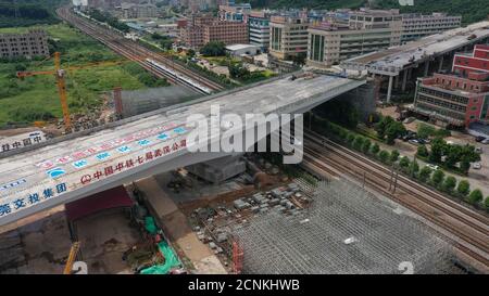 (200918) -- GUANGZHOU, 18. September 2020 (Xinhua) -- EIN Zug fährt nach der Rotation in Dongguan, südchinesische Provinz Guangdong, unter einer Drehbrücke entlang der Guangzhou-Shenzhen-Eisenbahn, 18. September 2020. Die 165 Meter lange, 33 Meter breite und 24,000 Tonnen schwere Drehbrücke, die über die Guangzhou-Shenzhen-Eisenbahn liegt, wurde am Freitag erfolgreich auf ihre Zielposition gedreht. (China Railway Seventh Group Co., Ltd./Handout über Xinhua) Stockfoto