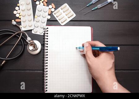 Medizinische Werkzeuge, Medizinische Rezepte . Spritze und bunte Medikamente und Kapseln Medizin Konzept, Holz Hintergrund, Vorderansicht, Nahaufnahme, Stockfoto