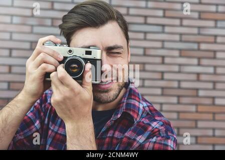 Sagen Cheese, Hipster Mode Fotograf Mann hält Retro-Kamera Stockfoto