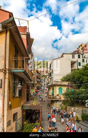 Schöne Porträtaufnahme der verkehrsreichen Straße Via Antonio Discovolo in Manarola, einer der berühmten Cinque Terre Städte in Italien. Touristen gehen die... Stockfoto