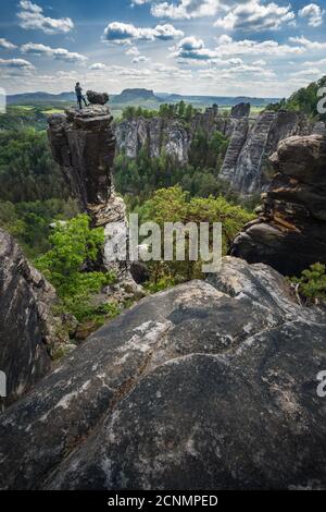 Unerkannte Silhouette Kletterer auf Berggipfel genießen berühmte Bastei Felsformation des Nationalparks Sächsische Schweiz, Deutschland. Frühlingszeit aktiv Stockfoto