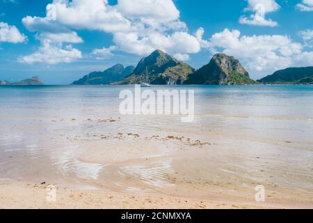 El Nido, Palawan, Philippinen. Yacht Boot in der Lagune von Las Cabanas Beach mit erstaunlichen Bergen im Hintergrund. Stockfoto