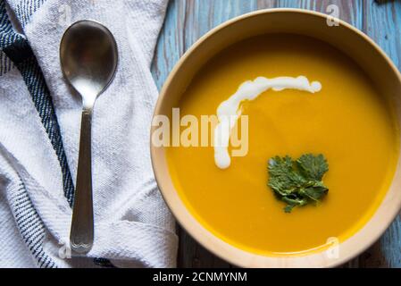 Kürbissuppe und Petersilienblatt in einer Schüssel auf einem Hintergrund Stockfoto