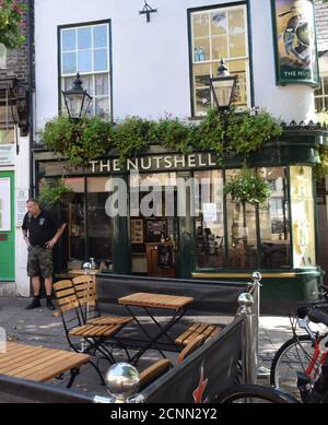 Der Manager vor dem Nutshell Pub in Bury St. edmunds, suffolk, england, großbritannien, kleinster Pub in england, mit neuen Sitzgelegenheiten im Freien während des 19 Stockfoto