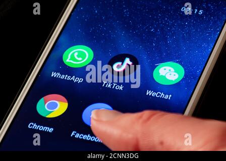 Nahaufnahme von TikTok und WeChat-Logo, App-Symbol auf einem Smartphone mit Finger angezeigt, Trump verboten und blockiert Stockfoto