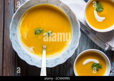 Eine Schüssel mit frischer Kürbissuppe in zwei kleinen Schüsseln serviert. Stockfoto
