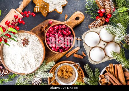 Zutaten für die Weihnachtsküche, Winterbäckchen, Lebkuchen, Obstkuchen, saisonale Getränke. Preiselbeeren, getrocknete Orangen, Zimt, Gewürze, Mehl Stockfoto