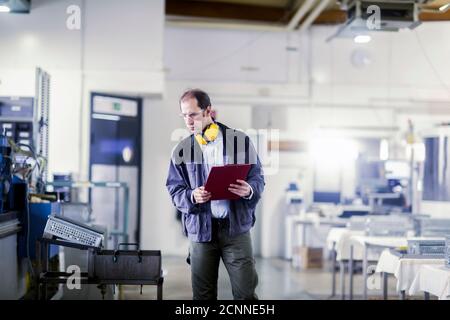 Techniker, der die Ausrüstung in einem Industriewerk, Deutschland, überprüft Stockfoto
