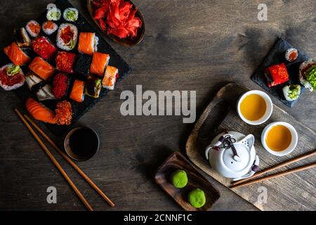 Blick von oben auf eine Auswahl an Nigiri und Maki Roll Sushi mit Wasabi, eingelegtem Ingwer und grünem Tee Stockfoto