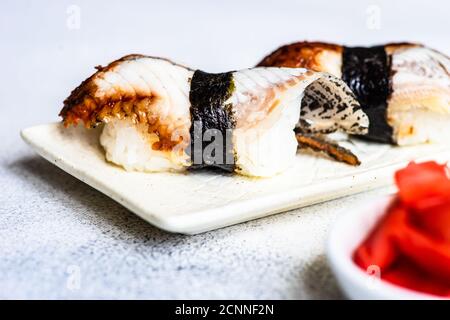 Nahaufnahme von zwei geräucherten Aal nigiri auf einem Teller Stockfoto