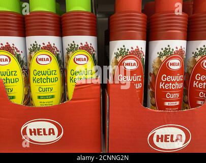 Viersen, Deutschland - 9. August. 2020: Blick auf Flaschen Hela Curry Ketchup Sauce im Regal des deutschen Supermarkts (Fokus auf zentrale Flaschen) Stockfoto
