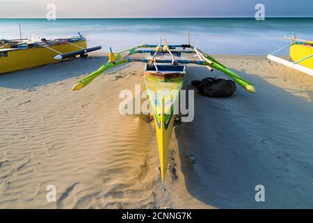 Traditionelle Jukungboote liegen am Strand, Philippinen Stockfoto