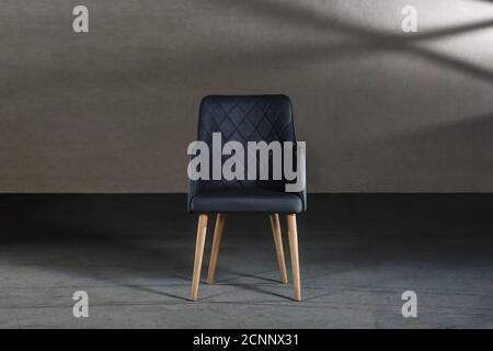 Bequemer Ohrensessel in einem Studio mit grauen Wänden Stockfoto