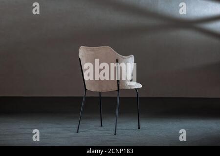 Bequemer weißer Ohrensessel in einem Studio mit grauen Wänden Stockfoto
