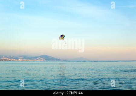 Menschen Parasailing in der Luft über dem Meer bei Sonnenuntergang, aktiver Sport Stockfoto