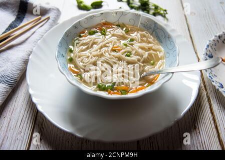 Thukpa, eine tibetische Delikatesse in einer Schüssel auf einem weißen Teller auf einem Hintergrund. Stockfoto