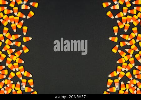 Halloween Süßigkeiten Mais doppelte Seitenrand. Draufsicht auf schwarzem Hintergrund mit Kopierplatz. Stockfoto
