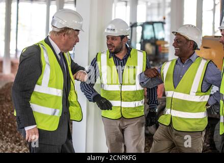 Premierminister Boris Johnson stößt mit Bauarbeitern auf die Ellbogen, als er die Baustelle des neuen Vaccines Manufacturing and Innovation Center (VMIC) besucht, das derzeit auf dem Harwell Science and Innovations Campus in der Nähe von Didcot gebaut wird. Das Gebäude wird für die Herstellung von Impfstoffen für Covid-19 gebaut und soll im nächsten Sommer eröffnet werden. Stockfoto