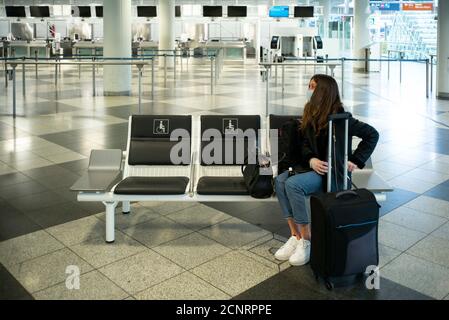 Corona Pandemie, Flughafen München, Zentralbereich, Fluggast mit Schutzmaske, verlassen. Stockfoto