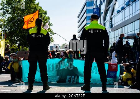 Amsterdam, Niederlande. September 2020. Klimaaktivisten sahen während der Demonstration auf dem Boden sitzen und ein Banner vor der Polizei halten.vor der Blockade versammelten sich Klimaaktivisten während einer legalen Demonstration am Gustav Mahlerplein, wo die Roten Rebellen auftauchten. Danach blockierten die Aktivisten die Hauptstraße des Finanzdistrikts während eines friedlichen zivilen Ungehorsams. Mit diesen Aktionen fordert XR eine Bürgerversammlung für eine faire Klimapolitik. Nach einigen Stunden wurden mehrere von ihnen von der niederländischen Polizei verhaftet. Kredit: SOPA Images Limited/Alamy Live Nachrichten Stockfoto