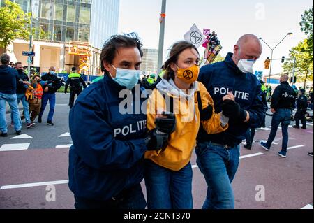 Amsterdam, Niederlande. September 2020. Eine Klimaaktivistin, die während der Demonstration von der niederländischen Polizei verhaftet wurde.vor der Blockade versammelten sich Klimaaktivisten während einer legalen Demonstration am Gustav Mahlerplein, wo die Roten Rebellen auftauchten. Danach blockierten die Aktivisten die Hauptstraße des Finanzdistrikts während eines friedlichen zivilen Ungehorsams. Mit diesen Aktionen fordert XR eine Bürgerversammlung für eine faire Klimapolitik. Nach einigen Stunden wurden mehrere von ihnen von der niederländischen Polizei verhaftet. Kredit: SOPA Images Limited/Alamy Live Nachrichten Stockfoto