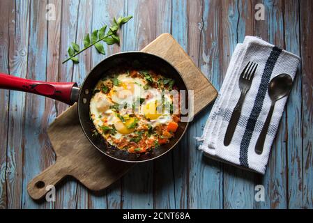 Shakshuka, eine mittelöstliche Delikatesse in einer schwarzen Pfanne auf einem Hintergrund Stockfoto