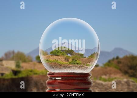 Pompejanische Landschaft an einem sonnigen Sommertag mit Vesuv in Der Hintergrund durch eine gläserne transparente Kugel Stockfoto