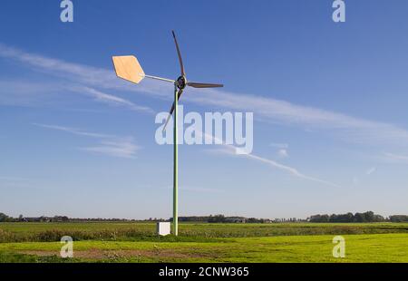 Eine kleine Windturbine mit handgeschnitzten Holzschaufeln, eine Windturbine mit einem ästhetischen Reiz Stockfoto