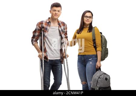 Männlicher Student mit Krücken und eine Schülerin, die ihm hilft Isoliert auf weißem Hintergrund Stockfoto
