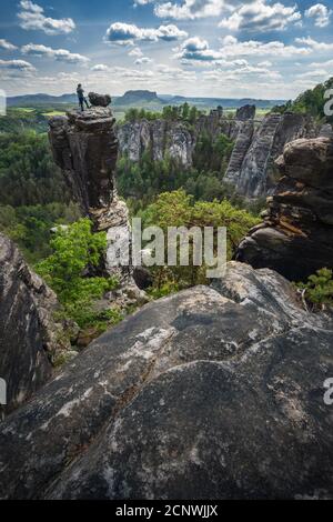 Unerkannte Silhouette Kletterer auf Berggipfel genießen berühmte Bastei Felsformation des Nationalparks Sächsische Schweiz, Deutschland. Frühlingszeit aktiv Stockfoto