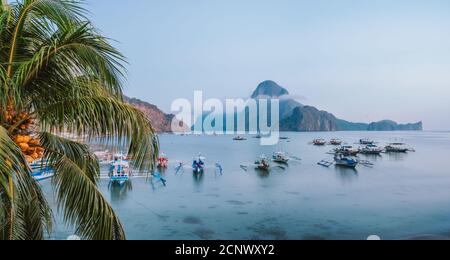 Panorama-Szene der Reise Touristenboote in El Nido am Abend Sonnenuntergang Licht. Palawan, Philippinen. Cadlao Insel im Hintergrund. Stockfoto