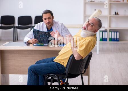 Alter Hals verletzten Mann besucht jungen Arzt Radiologen Stockfoto