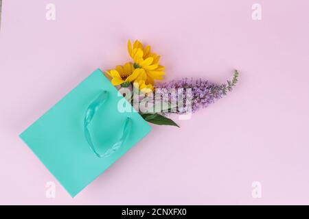 Wilde Blumen, gelb und lila in einer Geschenktüte, Grußkonzept, Geschenk. Platz für Text Stockfoto