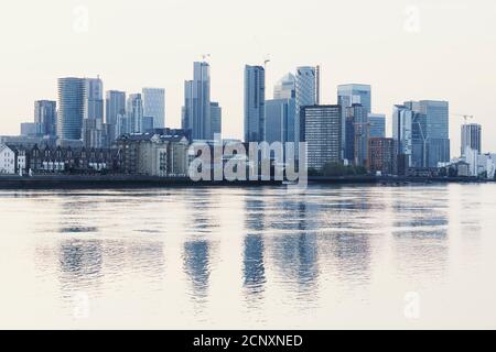 Wolkenkratzer im Finanzviertel Canary Wharf spiegeln sich in der Themse, London, Großbritannien. Stockfoto
