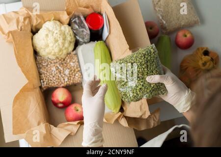 Ein Freiwilliger packt Essen in eine Sozialhilfe-Box. Spende. Stockfoto