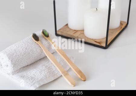 Keramikbecher mit Holzzahnbürsten auf weiß mit Kopierraum. Ökologische Material und Zahnpflege Stockfoto