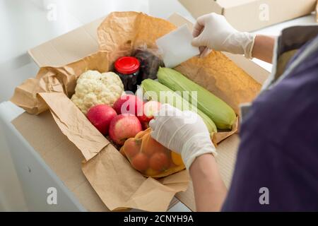 Ein Freiwilliger packt Essen in eine Sozialhilfe-Box. Spende. Stockfoto