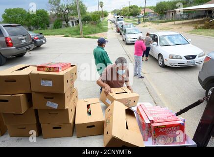 El Cenizo, TX USA 17. September 2020: Lokale Freiwillige verteilen Lebensmittelkisten an Bewohner der colonia von El Cenizo etwa 10 Meilen südlich von Laredo entlang der Texas-Mexiko-Grenze. Etwa 450 Familien werden zweimal in der Woche mit Heftklammern und frischem Obst in einer von der lateinamerikanischen lutherischen Mission (LALM) gesponserten Bemühung serviert. Aufgrund der Coronavirus-Pandemie ist die Verteilung nun ein sozial distanziertes Drive-Through-Ereignis, bei dem Freiwillige und Kunden alle Gesichtsbezüge tragen. Kredit: Bob Daemmrich/Alamy Live Nachrichten Stockfoto